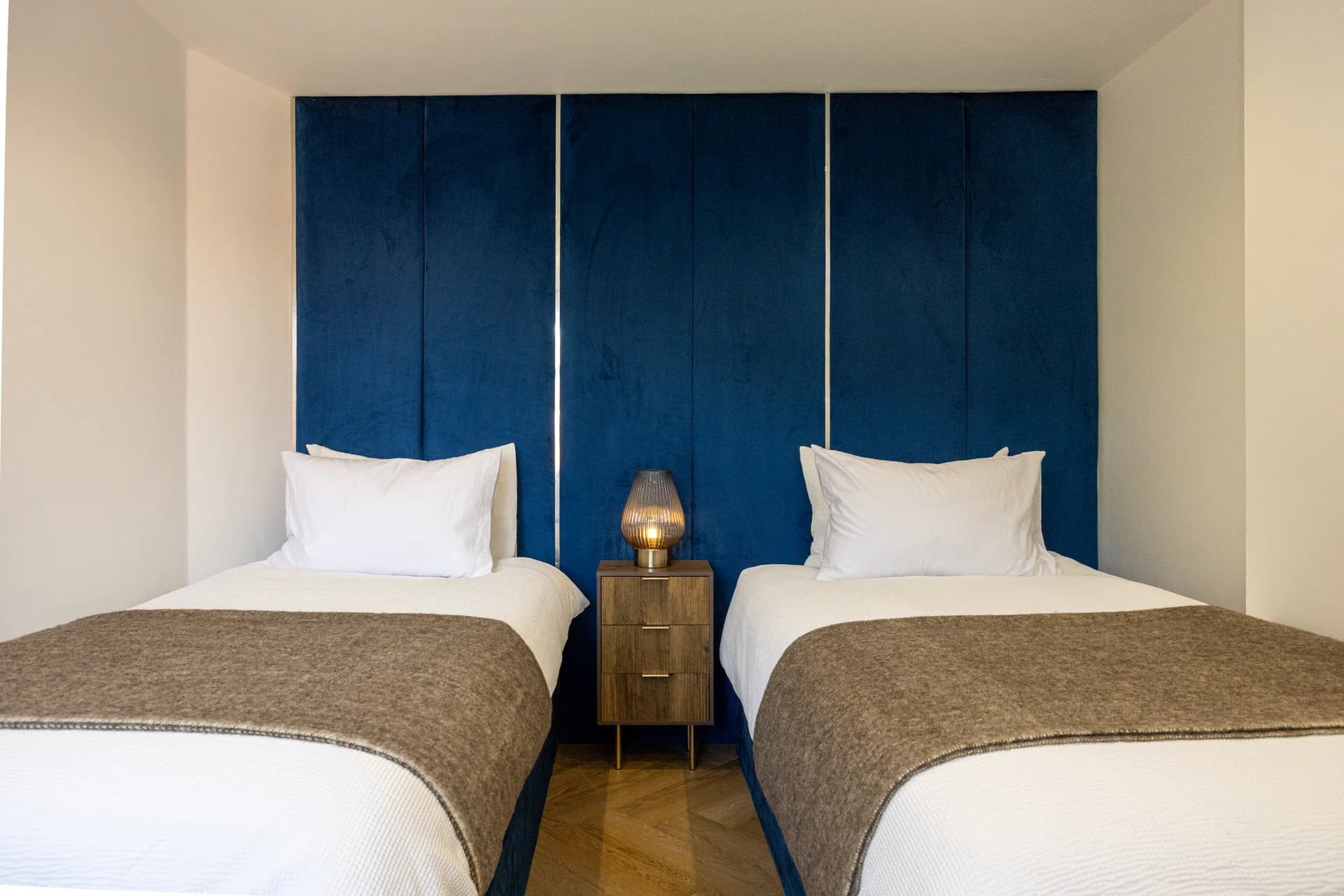 Twin bedroom with blue headboard wall at Meadow Croft, Wythenshawe
